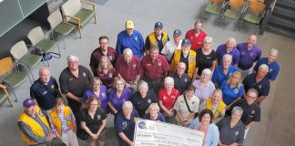 Representatives from Lions Club Districts A3 and A16 as well as 21 individual Lions Clubs from across the greater Kawarthas region presented Peterborough Regional Health Centre (PRHC) Foundation president and CEO Lesley Heighway (bottom right) with a donation of $100,000 on July 9, 2025 in support of the Campaign for PRHC and the expansion of the pediatric cancer care clinic at the regional hospital. (Photo courtesy of PRHC Foundation)