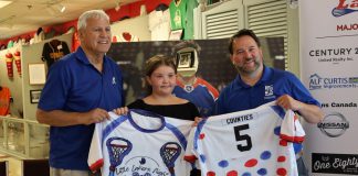 A fundraiser for Five Counties Children's Centre, Little Lakers Night returns to the Peterborough Memorial Centre on July 24, 2025 when the Peterborough Century 21 Lakers take on the Brampton Excelsiors in their final home game of the regular Major Series Lacrosse season. Pictured during a media event on July 15 are Lakers board chair Len Powers (left) and Five Counties CEO Scott Pepin (right) with nine-year-old Kennedy Meredith, who designed the special jersey that Lakers players will wear during the pre-game warmup before being auction off in support of Five Counties. (Photo: Peterborough Century 21 Lakers)