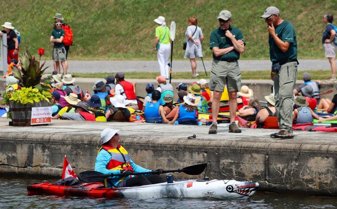 A paddler chats with Parks Canada employees during the seventh annual Lock & Paddle event at the Peterborough Lift Lock on July 19, 2025. (Photo: Sean Bruce)