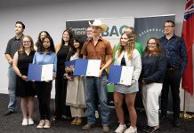 The graduates of the Summer Company program administered by the Business Advisory Centre (BAC) of Community Futures Peterborough (CFP) were celebrated at an event on August 13, 2025 at Venture North in downtown Peterborough. The graduates (holding certificates) are, left to right, Bisma Razaque, Neha Mervin, Spencer Toth, and Lauren Connolly (absent are Haydon Meade and Teaghan Hartnett). Also pictured from left to right are Joel Porter on behalf of Peterborough-Kawartha MPP Dave Smith, BAC entrepreneurship officer Allison Adam, Peterborough DBIA executive director Nour Mazloum, BAC manager Rose Terry, City of Peterborough economic development director Darryl Julott, CFP executive director Devon Girard (hidden), Peterborough County economic development manager Rhonda Keenan, and Peterborough and Kawarthas Chamber of Commerce vice-president Joel Wiebe. (Photo courtesy of Community Futures Peterborough)
