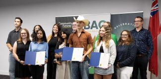 The graduates of the Summer Company program administered by the Business Advisory Centre (BAC) of Community Futures Peterborough (CFP) were celebrated at an event on August 13, 2025 at Venture North in downtown Peterborough. The graduates (holding certificates) are, left to right, Bisma Razaque, Neha Mervin, Spencer Toth, and Lauren Connolly (absent are Haydon Meade and Teaghan Hartnett). Also pictured from left to right are Joel Porter on behalf of Peterborough-Kawartha MPP Dave Smith, BAC entrepreneurship officer Allison Adam, Peterborough DBIA executive director Nour Mazloum, BAC manager Rose Terry, City of Peterborough economic development director Darryl Julott, CFP executive director Devon Girard (hidden), Peterborough County economic development manager Rhonda Keenan, and Peterborough and Kawarthas Chamber of Commerce vice-president Joel Wiebe. (Photo courtesy of Community Futures Peterborough)