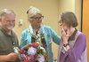 Incoming Northumberland Hills Hospital (NHH) Auxiliary president Rick Riley and Jennifer Gillard, NHH's vice-president of patient experience, public affairs, and strategic partnerships, present flowers to outgoing NHH Auxiliary president Selena Forsyth (right) at the auxiliary's annual meeting on July 24, 2025 at the Cobourg hospital. (Photo: NHH)