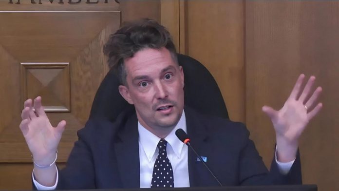 Peterborough city councillor Alex Bierk explains his motion to defer the proposed Community Wellbeing Fund, which would consolidate the city's funding streams for community project grants, community investment grants, and community service grants, during a general committee meeting on August 5, 2025. (kawarthaNOW screenshot of City of Peterborough video)