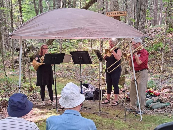 Jane Cook (left) plays the French horn with Ruth Alton and David Archer on trombone for an audience during the inaugural Musical Nature Walk hosted by the Peterborough Symphony Orchestra and the Peterborough Field Naturalists in 2024. David Archer will once again be performing during the 2025 walk on Saturday, September 6, when he will be joined by PSO maestro Michael Newnham, who is stepping away from the conductor's podium to also perform on trombone. (Photo courtesy of Peterborough Symphony Orchestra)