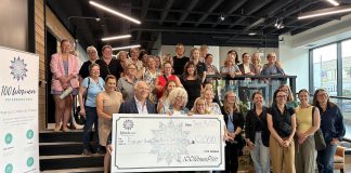 Kawartha Youth Orchestra volunteer John Good and board vice chair Joy Simmonds accept a $10,000 donation from 100 Women Peterborough founding member Wendy Hill as other members of the collective philanthropy group look on during the group's third meeting of 2025 in the lobby of the Venture North building on Tuesday, September 16. (Photo courtesy of 100 Women Peterborough)