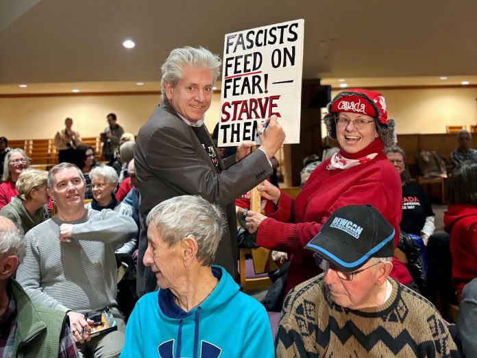 Charlie Angus signs an audience member's anti-fascism sign on April 2, 2025 during a stop in Sudbury for his Resistance Tour. (Photo courtesy of Charlie Angus)