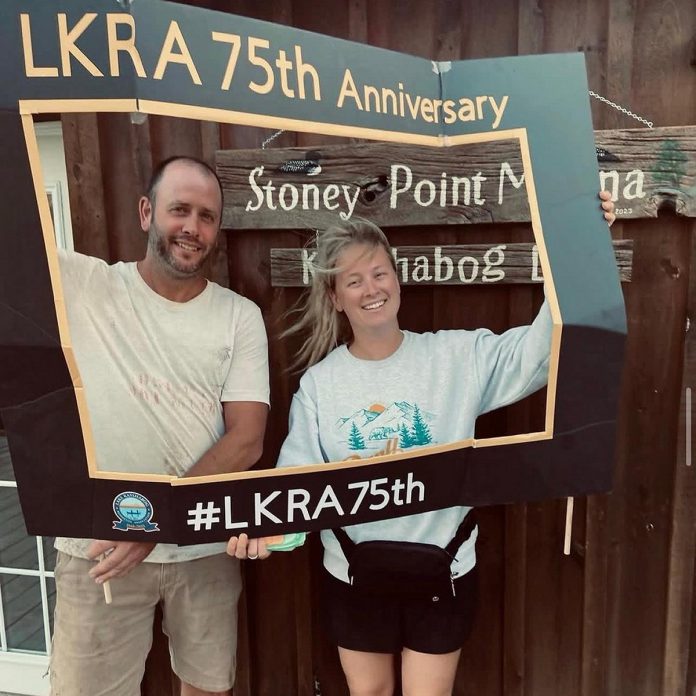 Husband-and-wife team Haley and Bryan Bates celebrating the 75th anniversary of the Lake Kasshabog Residents Association in 2023, the same year they purchased Stoney Point Marina on the shore of Kasshabog Lake in the Township of Havelock-Belmont-Methuen. In addition to regularly giving to community organizations and initiatives when they can, during the spring ice storm, the couple opened the marina kitchen and served free fish and chips to community members without power. (Photo courtesy of Stoney Point Marina)