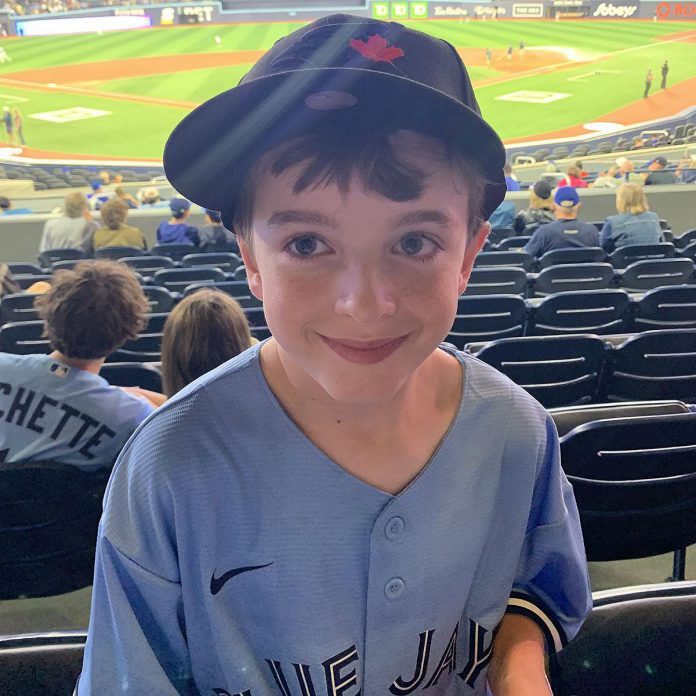 Now 11 years old, Max is thriving after receiving treatment at Five Counties Children's Centre for serious challenges he experienced as a baby. In this recent photo, he attended a Blue Jays baseball game in Toronto. (Photo courtesy of Five Counties Children's Centre)