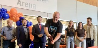 Grace Bowen's father Greg cuts the ribbon during a ceremony on September 14, 2025 at the Cobourg Community Centre to officially rename the Pond Arena as the Grace Bowen Arena, as actor Ryan Reynolds (far right) stands beside Grace's mother Andrea and sister Mackenzie. In April, Reynolds appeared before a committee of Cobourg council on behalf of the Bowen family to request the arena be renamed in memory of the nine-year-old Grafton hockey player who passed away from an aggressive form of bone cancer in 2015. (Photo: Natalie Hamilton / kawarthaNOW)