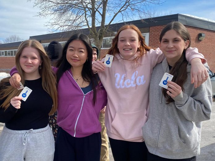 Students from Queen Mary Public School show off their transit passes for Grade 8 Transit Quest, a transit encouragement campaign organized by Active School Travel Peterborough. Transit ridership in youth is important for building life skills, accessing extracurricular opportunities, and fostering independence. (Photo: Natalie Stephenson / GreenUP)