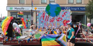 A float during the Peterborough-Nogojiwanong Pride Parade on September 27, 2025 includes the Pride Week theme of "All of Us or None," which reflects the challenges facing the global 2SLGBTQIA+ community with the rise of anti-trans legislation, the banning of 2SLGBTQIA+ books in schools and libraries, and the withdrawal of public support by some organizations and businesses for progressive causes. (Photo courtesy of Sean Bruce)
