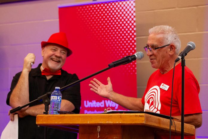 United Way Peterborough & District CEO Jim Russell laughs as 2025-26 campaign chair Paul Rellinger speaks at the podium during the official launch of the United Way's 2025-26 community campaign on September 25, 2025 at the Healthy Planet Arena. (Photo: Jordan Lyall Photography)