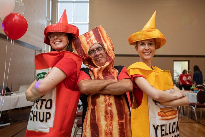 United Way Peterborough & District's 2025-26 campaign chair Paul Rellinger (middle) helps promote the new Ultimate Burger Battle fundraising intiative announced during the official launch of the United Way's 2025-26 community campaign on September 25, 2025 at the Healthy Planet Arena in Peterborough. (Photo: Jordan Lyall Photography)
