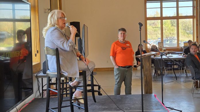 As Peterborough and Kawarthas Chamber of Commerce president and CEO Brenda Whitehead looks on, Peterborough County Warden Bonnie Clark addresses the audience during the second annual Warden's Breakfast in the Peterborough County Agricultural Heritage Building at Keene's Lang Pioneer Village Museum on September 30, 2025. (Photo: Jeannine Taylor / kawarthaNOW)