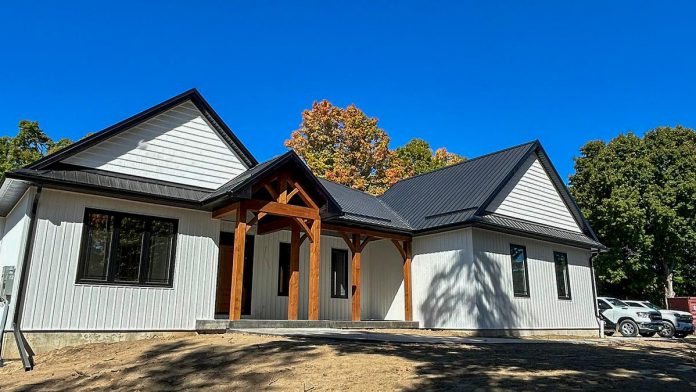 Along with roof replacements, Bullarco Roofing & Full Exterior services new builds like this home in Havelock, where the company installed a gloss black exposed-fastener metal roof this summer. (Photo courtesy of Bullarco Roofing & Full Exteriors)