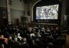 An audience in Stratford watches a screening of "We Lend A Hand: The Forgotten Story of Ontario Farmerettes", produced and directed by Colin Field with historical producer Bonnie Sitter, who wrote the 2019 book "Onion Skins and Peach Fuzz: Memories of Ontario Farmerettes" with retired journalist Shirleyan English. (Photo via welendahand.ca)