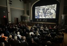An audience in Stratford watches a screening of "We Lend A Hand: The Forgotten Story of Ontario Farmerettes", produced and directed by Colin Field with historical producer Bonnie Sitter, who wrote the 2019 book "Onion Skins and Peach Fuzz: Memories of Ontario Farmerettes" with retired journalist Shirleyan English. (Photo via welendahand.ca)