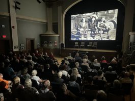 An audience in Stratford watches a screening of "We Lend A Hand: The Forgotten Story of Ontario Farmerettes", produced and directed by Colin Field with historical producer Bonnie Sitter, who wrote the 2019 book "Onion Skins and Peach Fuzz: Memories of Ontario Farmerettes" with retired journalist Shirleyan English. (Photo via welendahand.ca)