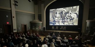 An audience in Stratford watches a screening of "We Lend A Hand: The Forgotten Story of Ontario Farmerettes", produced and directed by Colin Field with historical producer Bonnie Sitter, who wrote the 2019 book "Onion Skins and Peach Fuzz: Memories of Ontario Farmerettes" with retired journalist Shirleyan English. (Photo via welendahand.ca)