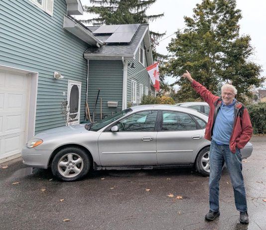Lakefield resident Guy Hanchet proudly displays his newly installed solar panels. Despite not having an ideal rooftop for solar, he expects to power about half of his annual electricity use from the system. (Photo: Clara Blakelock / GreenUP)