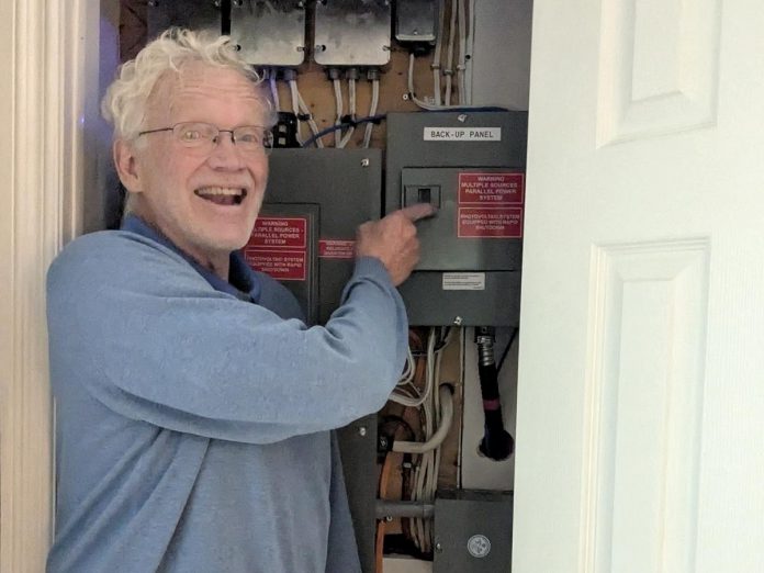 Having backup power was a key driver of Lakefield resident Guy Hanchet's decision to install his new solar system. Here he points to his backup panel, which is connected to several essential circuits in his home. (Photo: Clara Blakelock / GreenUP)