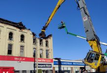 A grapple removes debris from the fire-devastated Kawartha Home Hardware building in downtown Lakefield on October 12, 2025 as a Priestly Demolition Inc. employee supervises from a boom truck. (Photo: Scott Norwood)