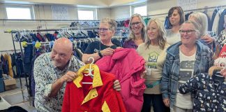 United Way Peterborough & District CEO Jim Russell and Bev Assinck of Peterborough Action for Tiny Homes (PATH) hold up clothing on October 8, 2025 during the launch of the annual Coats for Community campaign at PATH's location at 385 Lansdowne Street East in Peterborough. (Photo: United Way Peterborough & District)
