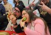 "Burger ambassadors" Jason Wilkins and Tiffany Arcari sink their teeth into burger creations from Double Dz's and Chemong Lodge (with Chemong Lodge's sous chef Sean Crooks giving the victory sign) during the launch of the United Way Peterborough & District's inaugural Ultimate Burger Battle community fundraiser on October 30, 2025 at the United Way office. During the month of November, eight participating restaurants will be creating a unique and creative burger in a friendly competition for the title of Ultimate Burger of the Year, with $2 from every burger sold being donated to the United Way. (Photo: Jeannine Taylor / kawarthaNOW)