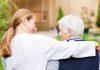 A young woman with her arm around the shoulders of an elderly person. (Stock photo)