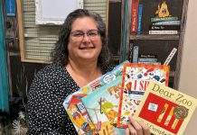 Speech-language pathologist Ida Lloyd at Five Counties Children's Centre displays a few of the books that clinicians at the regional treatment centre recommend parents and caregivers put under the tree for children this holiday season. (Photo: Five Counties Children's Centre)