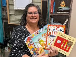 Speech-language pathologist Ida Lloyd at Five Counties Children's Centre displays a few of the books that clinicians at the regional treatment centre recommend parents and caregivers put under the tree for children this holiday season. (Photo: Five Counties Children's Centre)