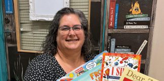 Speech-language pathologist Ida Lloyd at Five Counties Children's Centre displays a few of the books that clinicians at the regional treatment centre recommend parents and caregivers put under the tree for children this holiday season. (Photo: Five Counties Children's Centre)