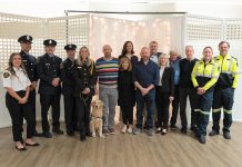 Wilfred Vienot (seventh from right), who suddenly collapsed in his home one day last year after suffering a cardiac arrest and was resuscitated thanks to community members and first responders, attended Northumberland County's 10th annual "Survivor Night" on October 27, 2025 with first responders from Lindsay Central Ambulance Communications Centre, Cobourg Fire Department, Northumberland Paramedics, and his neighbours and friends. (Photo: Northumberland County)