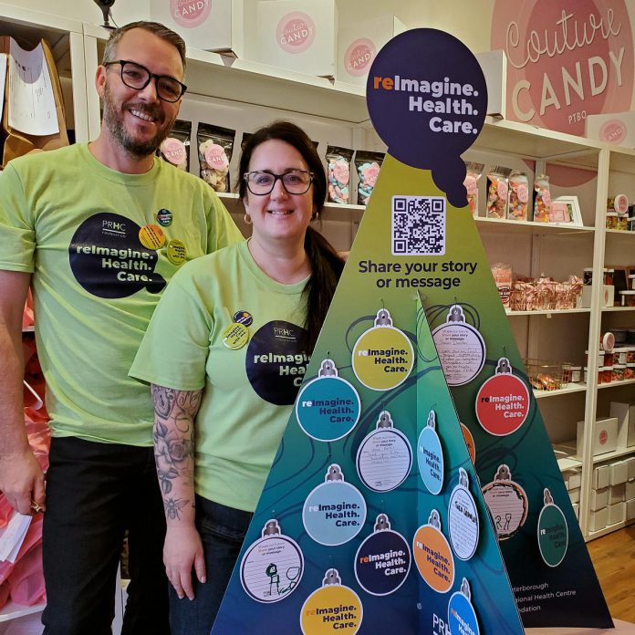 Couture Candy owners Matt and Lisa Couture stand with The Sharing Tree in their Peterborough business. An annual initiative of the Peterborough Regional Health Centre (PRHC) Foundation, The Sharing Tree encourages community members to share stories of their connection to the hospital on paper ornaments to be displayed on the tree throughout the holiday season. The tree will be popping up at partner businesses throughout the region. (Photo courtesy of PRHC Foundation)