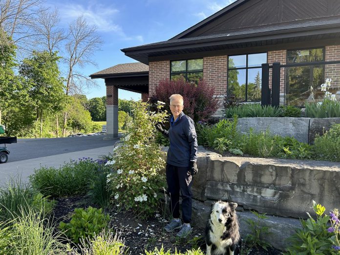 Peterborough Golf and Country Club gardener Joanne Brown (with club dog Skye) working on the gardens at the clubhouse. Brown plays an integral part in planting and caring for the club's gardens, including the pollinator garden. (Photo: Kevin Kobzan / Peterborough Golf and Country Club)