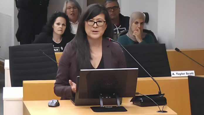 Sacha Lai-Svirk, volunteer board chair of the Peterborough Downtown Business Improvement Area (DBIA), addresses Peterborough city council during a meeting on December 1, 2025 to consider a proposed by-law that would see the City of Peterborough assume administrative control of a $150,000 annual payment from the city to the DBIA as part of a 20-year settlement agreement made in 2017. (kawarthaNOW screenshot of City of Peterborough video)