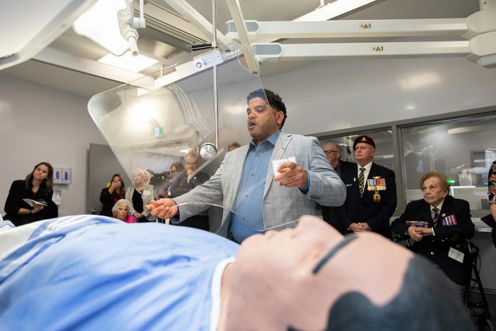 Dr. Fady Abdelsayed, interventional radiologist at Peterborough Regional Health Centre (PRHC), demonstrates the use of the protective shields on either side of the operating table in one of the hospital's upgraded interventional radiology suites during an event on December 9, 2025. A piece of equipment the original outdated 16-year-old suites did not have, the protection is one of many new technology upgrades made possible through a $6 million donor-funded investment. (Photo: Jordan Lyall / kawarthaNOW)