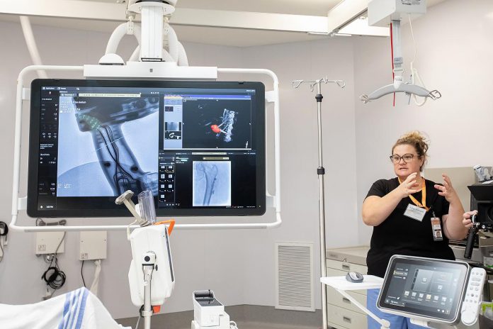 Julie Stinson, charge technologist at Peterborough Regional Health Centre (PRHC), demonstrates some of the software upgrades made possible through the $6 million-donor funded advancements to the interventional radiology suites during an event on December 9, 2025. The upgrades make it possible for the hospital's healthcare professionals to do more complex procedures with minimally invasive technologies, resulting in less risk, greater precision, and reduced wait times. (Photo: Jordan Lyall / kawarthaNOW)