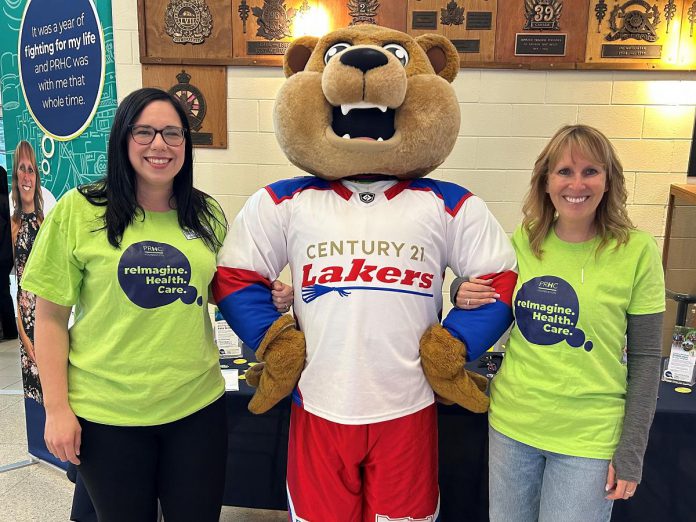 Ashley Marcoux, senior charitable giving advisor at the Peterborough Regional Health Centre (PRHC) Foundation, and grateful patient and ReImagineer Jennie Ireland with the Peterborough Century 21 Lakers mascot Teddy. Through a partnership with the lacrosse team, the PRHC Foundation attended the home games throughout the 2025 season to tell fans about the Foundation's $70 million Campaign for PRHC and how they can support world-class healthcare close to home, including by bringing digital pathology to the regional hospital. (Photo courtesy of PRHC Foundation)