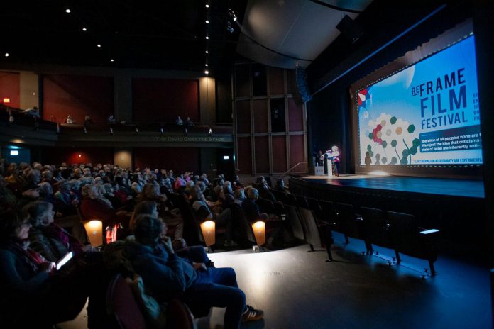 Almost all in-person screenings at the 2026 ReFrame Film Festival will be relaxed screenings, where audience members are welcome to move, leave, and reenter as needed, as well as make quiet sounds, or attend with support people, assistance animals, and babies. The relaxed screenings are one of the many features ReFrame has introduced to deliver a festival that is as accessible as possible by accommodating the physical, sensory, emotional, and financial needs of festiva-goers. The 2026 festival will run in person in downtown Nogojiwanong/Peterborough from January 30 to February 1 and online across Canada from February 3 to 8. (Photo courtesy of ReFrame Film Festival)