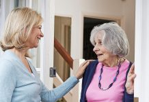 A woman checking on an elderly female neighbour. (Stock photo)