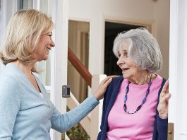 A woman checking on an elderly female neighbour. (Stock photo)