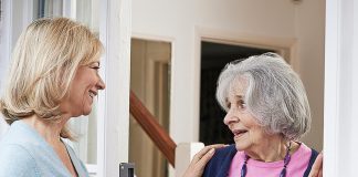 A woman checking on an elderly female neighbour. (Stock photo)