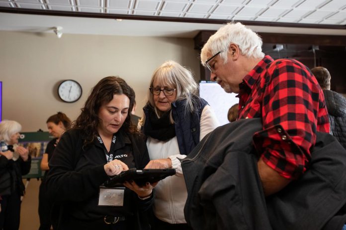 An Alto team member consults a tablet as she speaks with two attendees during an open house on the proposed high-speed rail network between Toronto and Quebec City held at the McDonnel Street Activity Centre in Peterborough on February 26, 2026. (Photo: Jordan Lyall / kawarthaNOW)