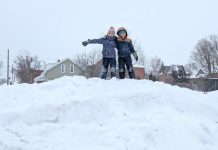Allowing children to engage in play is an important way kids make sense of the world and understand their own boundaries. Climbing a snow pile (in a safe location) during a winter walk to school is a great example of letting kids take reasonable risks and gain confidence through play. (Photo: Clara Blakelock / GreenUP)