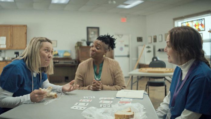 Naomi Snieckus, Leslie Adlam, and Kayla Lorette star in the Bobcaygeon episode of "I'm Also Here," a new comedy anthology TV series produced by Firecracker Department and C'mon Mort Productions and premiering on Bell Fibe TV1 on February 12, 2026. Filmed at Bobcaygeon Seniors Centre, the episode follows a quirky caregiver who risks everything to pursue a dream of becoming a stand-up comic, despite her co-worker's concern that she's not very funny. (Screenshot courtesy of Firecracker Department)