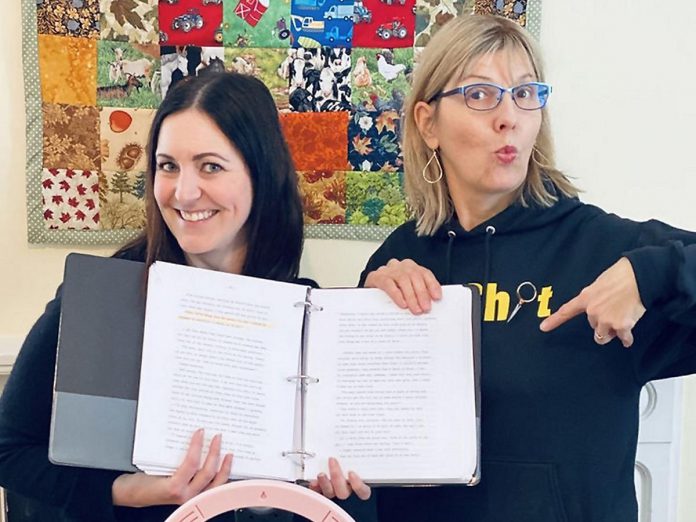 Megan Murphy and Leslie Bradford-Scott holding up the 545-page manuscript Bradford-Scott's late father wrote while serving 15 years in prison. Rather than being the drug dealer with delusions of grandeur she had always believed him to be, Bradford-Scott's father claimed he had been an informant for the CIA and FBI, causing her to question everything she knew about her family. During the pandemic, the women teamed up to host the seven-episode Rewriting Dad podcast as Bradford-Scott uncovered pieces of the truth as she connected with people who knew her father. (Photo courtesy of Leslie Bradford-Scott)