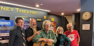 Joe Grant of LLF Lawyers, United Way Peterborough & District executive director Jim Russell, performer musician Mark Beatty, main stage emcee Ella Bates, and event co-founder and organizer Paul Rellinger during a media event at Showplace Performance Centre on February 12, 2026 to promote the Peterborough Performs VI: Musicians United To End Homelessness benefit concert on Thursday, February 26. (Photo: Adeline Murphy / United Way)