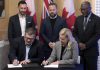 Ontario Power Generation senior vice president Paul Séguin and Port Hope mayor Olga Hankivsky sign a memorandum of understanding (MOU) at the Nuclear Discovery Centre in Port Hope on February 12, 2026 to advance what would be the world's largest nuclear power plant, located in Wesleyville. (kawarthaNOW screenshot of Ontario government video)