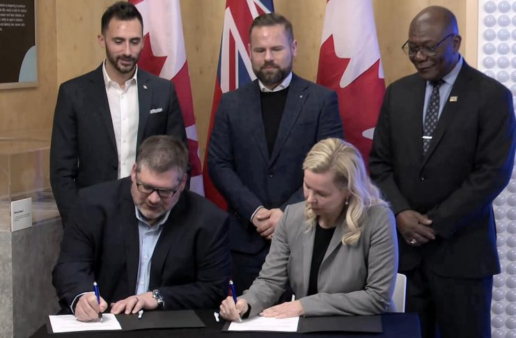 Ontario Power Generation senior vice president Paul Séguin and Port Hope mayor Olga Hankivsky sign a memorandum of understanding (MOU) at the Nuclear Discovery Centre in Port Hope on February 12, 2026 to advance what would be the world's largest nuclear power plant, located in Wesleyville. (kawarthaNOW screenshot of Ontario government video)
